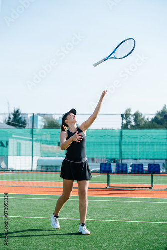 Young girl playing with racket, throwing it up in the air and flipping © zzzdim