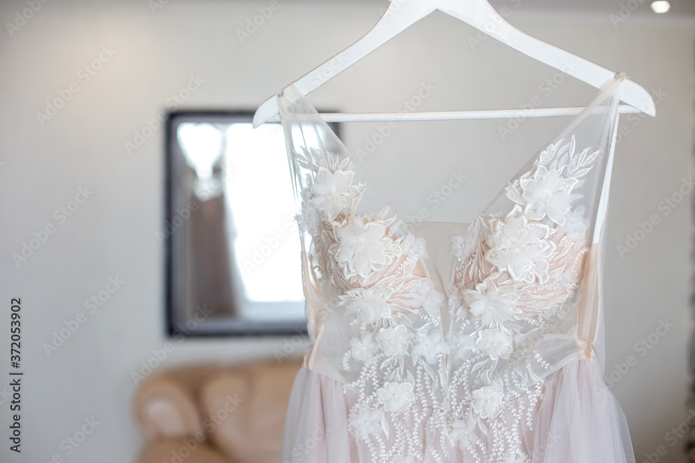 Luxury Lace Wedding Dress Hanging in room. Luxury Lace Wedding Dress Hanging in room.
