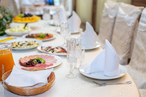 Tasty dishes on a served white banquet table in a luxury restaurant.