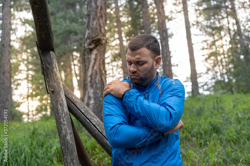 Pretty young beard man athlete feeling pain in his shoulder. Exercising injury concept.