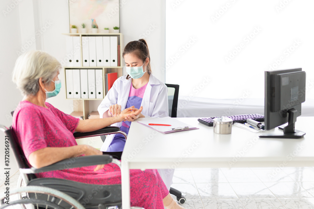 asian doctor use hand screening vital sign of old asian patient, doctor treatment patient in hospital, elderly health check up, they wear surgical mask asian doctor use hand screening vital sign of old asian patient, doctor treatment patient in hospital, elderly health check up, they wear surgical mask
