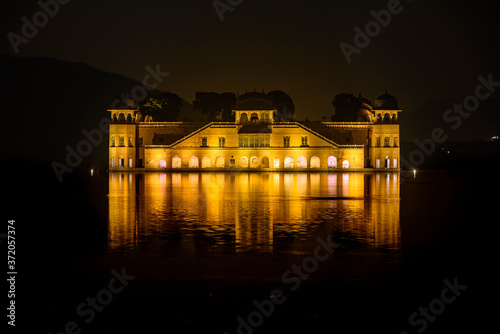 Fototapeta Naklejka Na Ścianę i Meble -  Illuminated night view of Jal Mahal 'Water Palace' is an architectural showcase of Rajput style in the Man Sagar lake in jaipur city, the capital of Rajasthan, India.