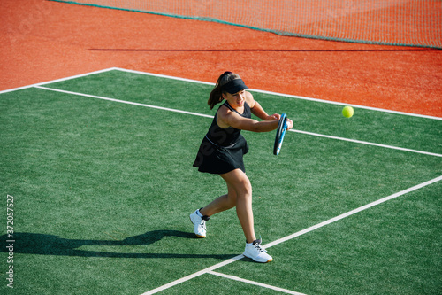 Sixting year old girl playing tennis on a new court, returning ball © zzzdim