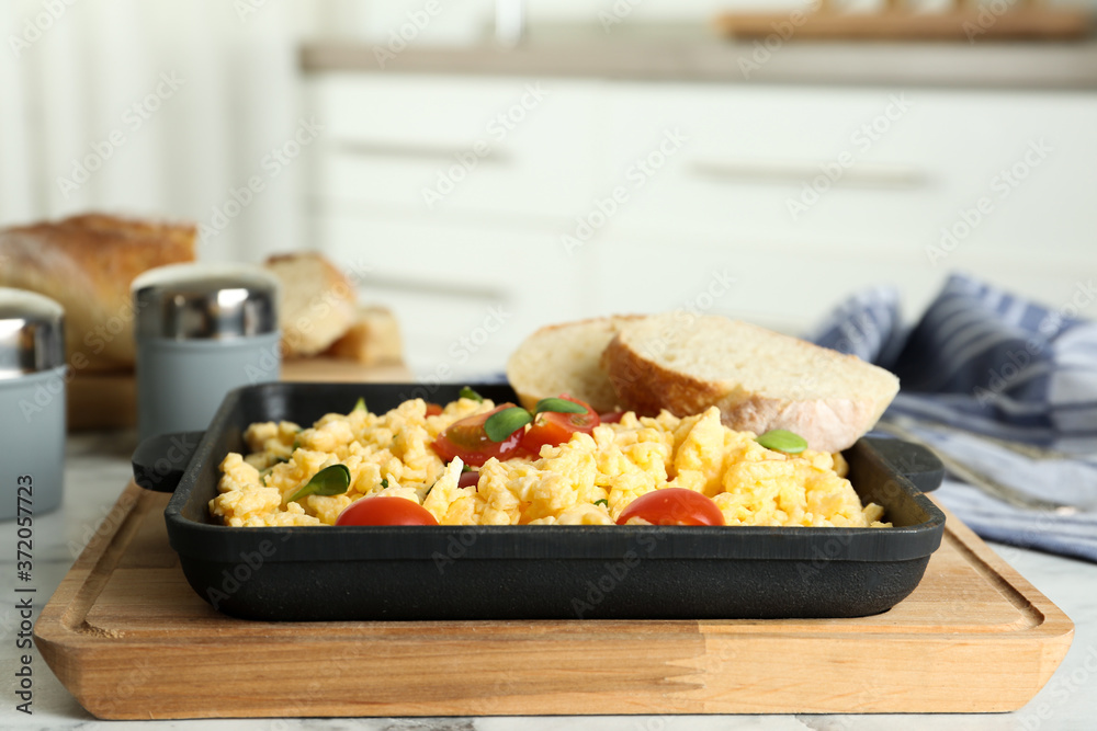 Tasty scrambled eggs with sprouts, cherry tomato and bread in frying pan on table Tasty scrambled eggs with sprouts, cherry tomato and bread in frying pan on table