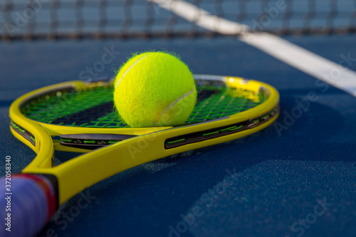 Tennis ball on racket sitting by the net © joescarnici