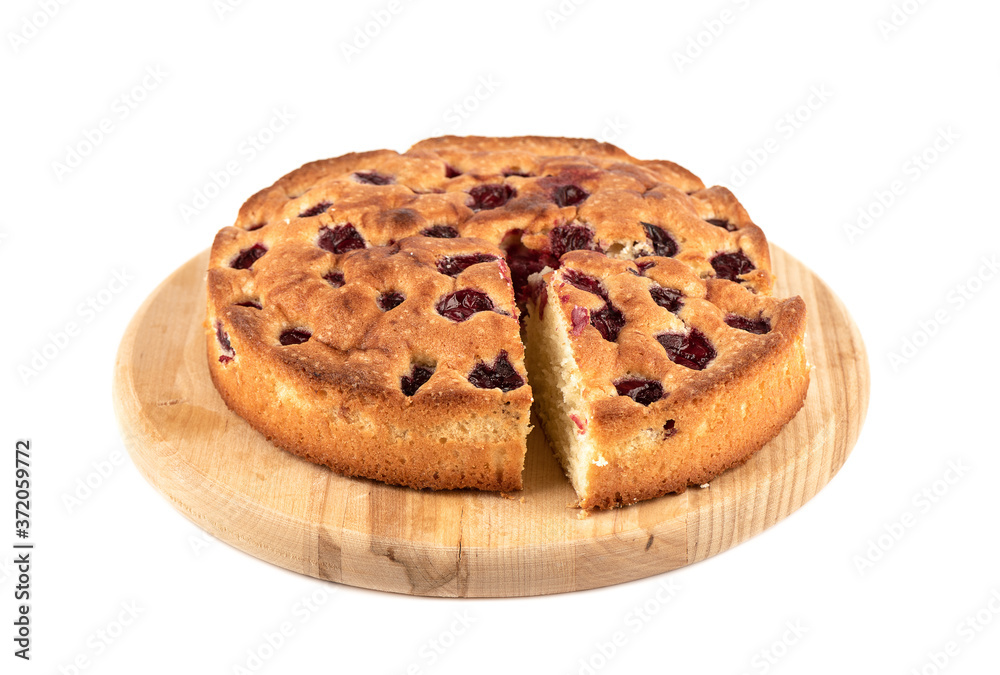 Cherry pie with cut triangular slice on a cutting board over white background. Cherry pie with cut triangular slice on a cutting board over white background.