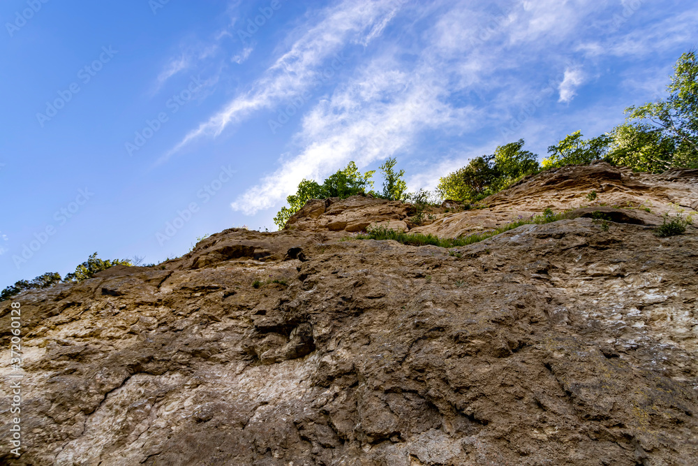 Rock with soil layers against blue sky.