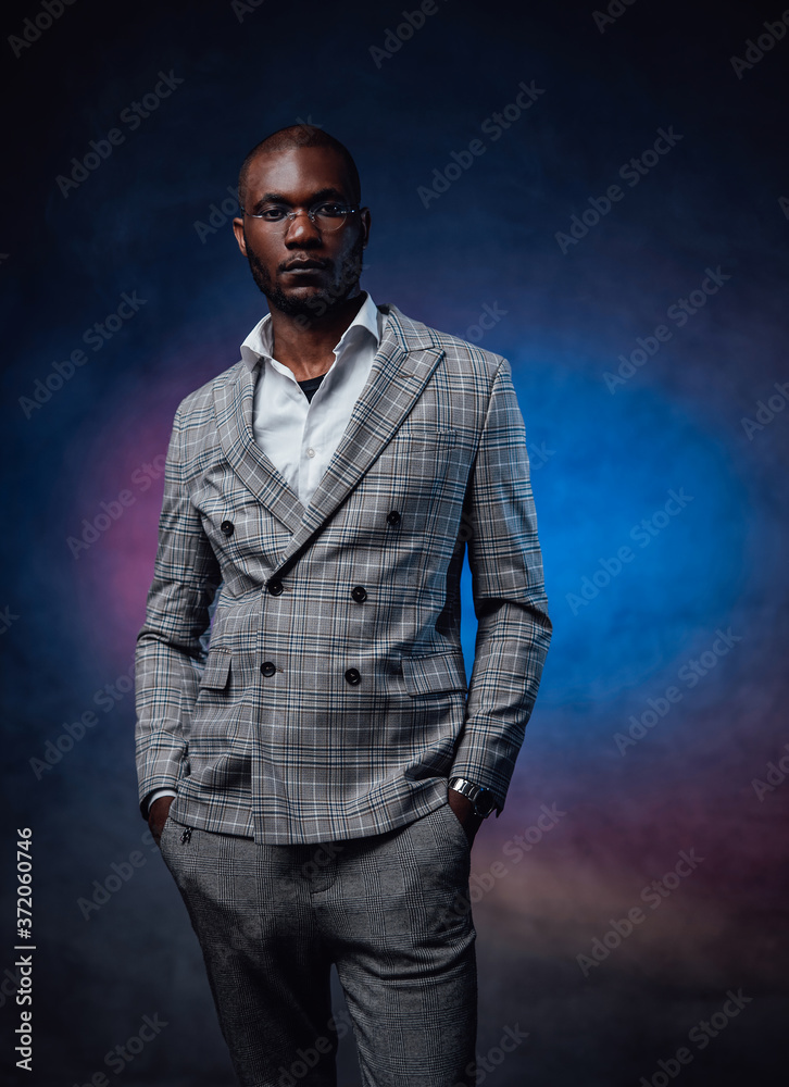 Business expensive stylish costume and african person dressed in it. A serious looking man dressed in rich clothes.