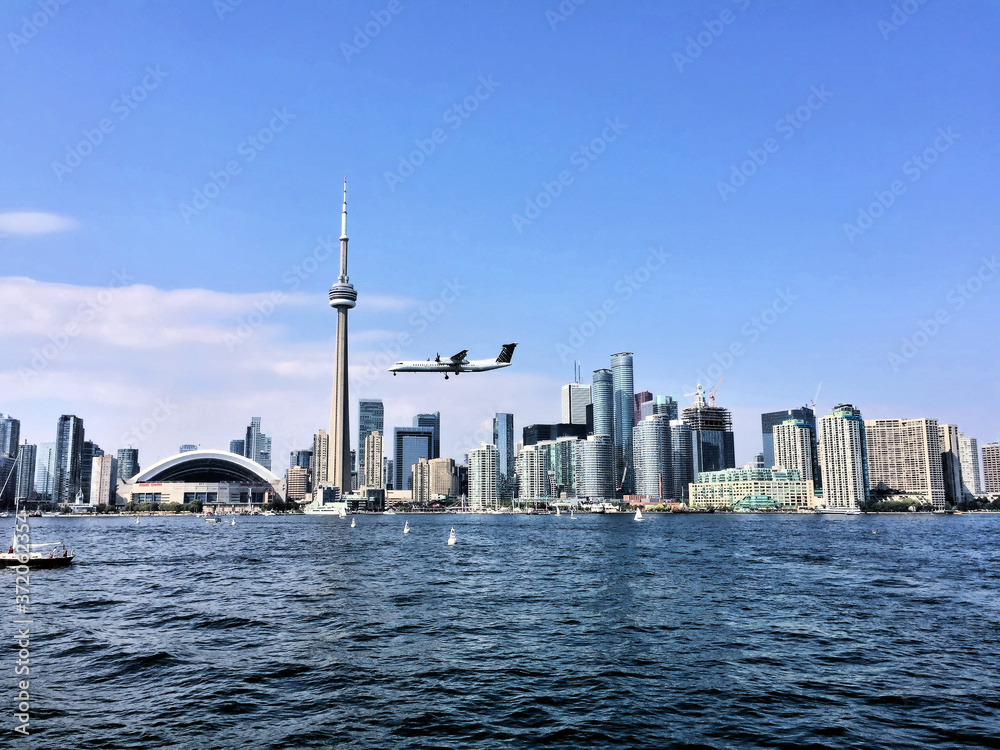 A view of Toronto from the sea with a plane coming in to land