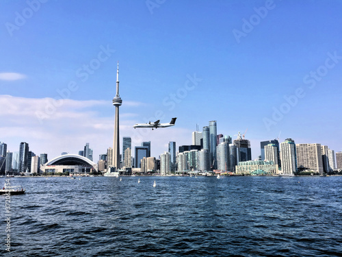 A view of Toronto from the sea with a plane coming in to land