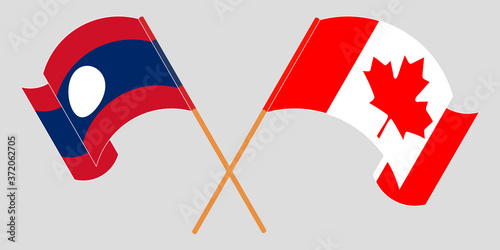 Crossed and waving flags of Laos and Canada