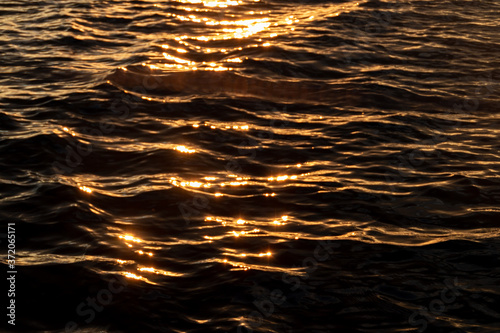 Blurred abstracted sun flare, sunset light on water surface 