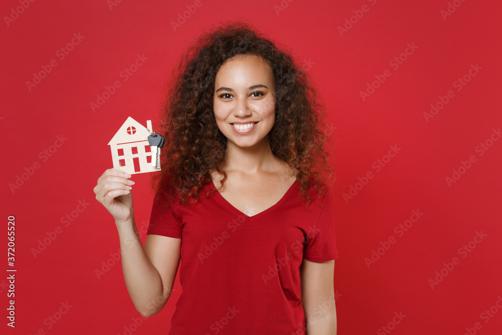 Smiling young african american woman girl in casual t-shirt posing isolated on red background studio portrait. People sincere emotions lifestyle concept. Mock up copy space. Hold house, bunch of keys. Smiling young african american woman girl in casual t-shirt posing isolated on red background studio portrait. People sincere emotions lifestyle concept. Mock up copy space. Hold house, bunch of keys.