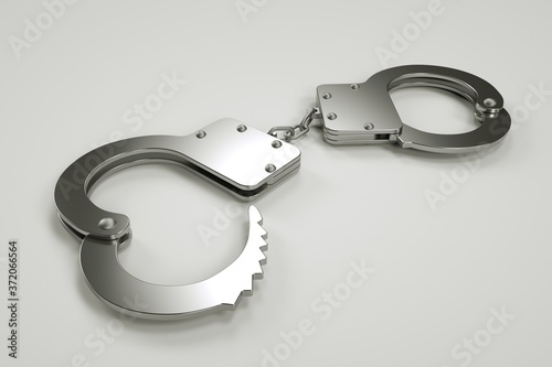 Metal handcuffs lie on a gray background, arrest and detention, violation of the law