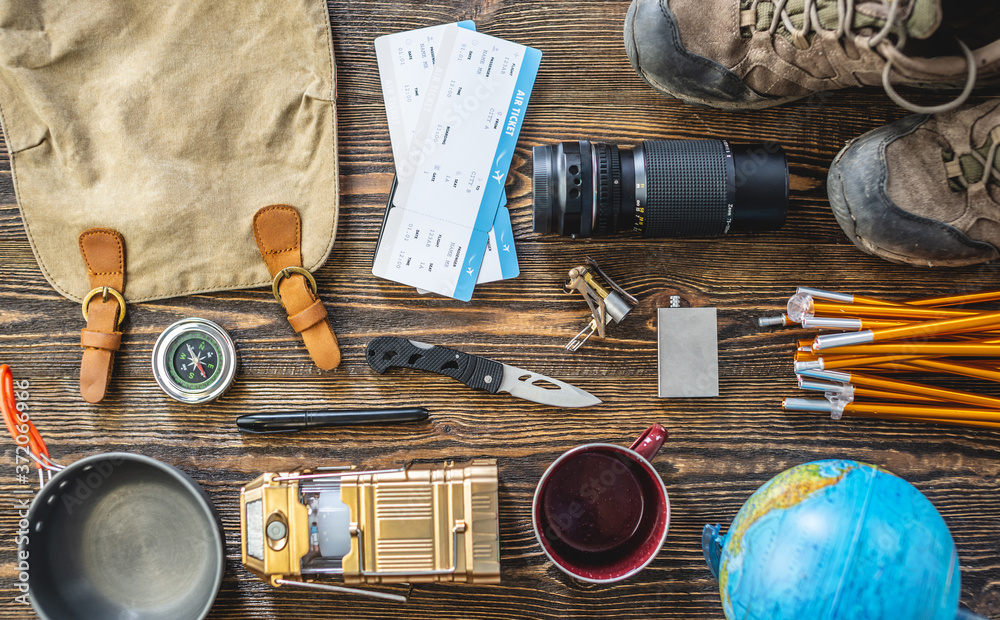Hiking equipment for tourism on wooden table. Concept of travel and discovery Hiking equipment for tourism on wooden table. Concept of travel and discovery