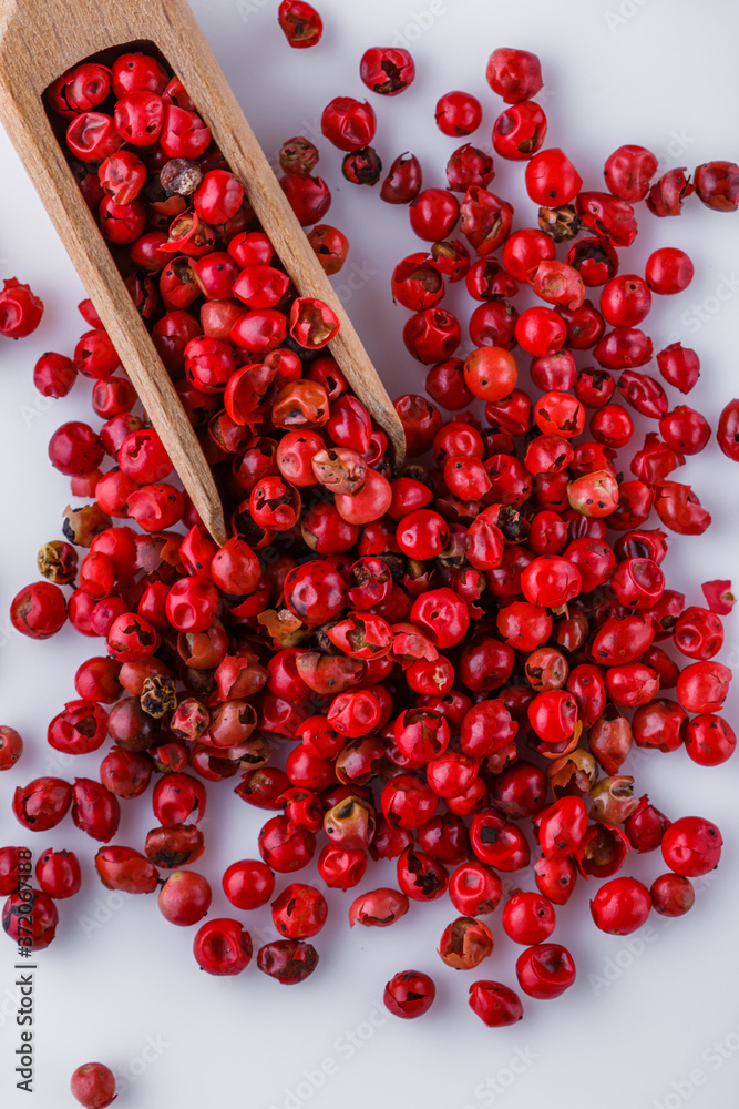 fragrant pink peppercorns on white acrylic background fragrant pink peppercorns on white acrylic background