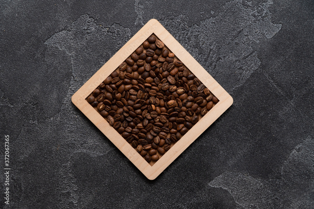 Coffee beans in wooden box on a dark surface. Coffee beans in wooden box on a dark surface.