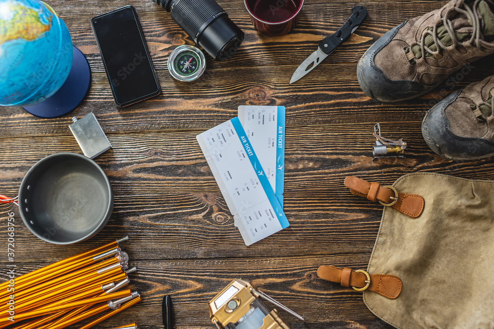 Hiking equipment for tourism on wooden table. Concept of travel and discovery Hiking equipment for tourism on wooden table. Concept of travel and discovery