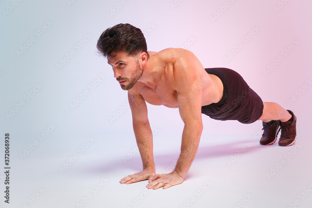 Full length portrait young fitness sporty strong guy bare-chested muscular sportsman isolated on white background studio portrait. Workout sport motivation lifestyle concept. Doing push-ups exercises. Full length portrait young fitness sporty strong guy bare-chested muscular sportsman isolated on white background studio portrait. Workout sport motivation lifestyle concept. Doing push-ups exercises.