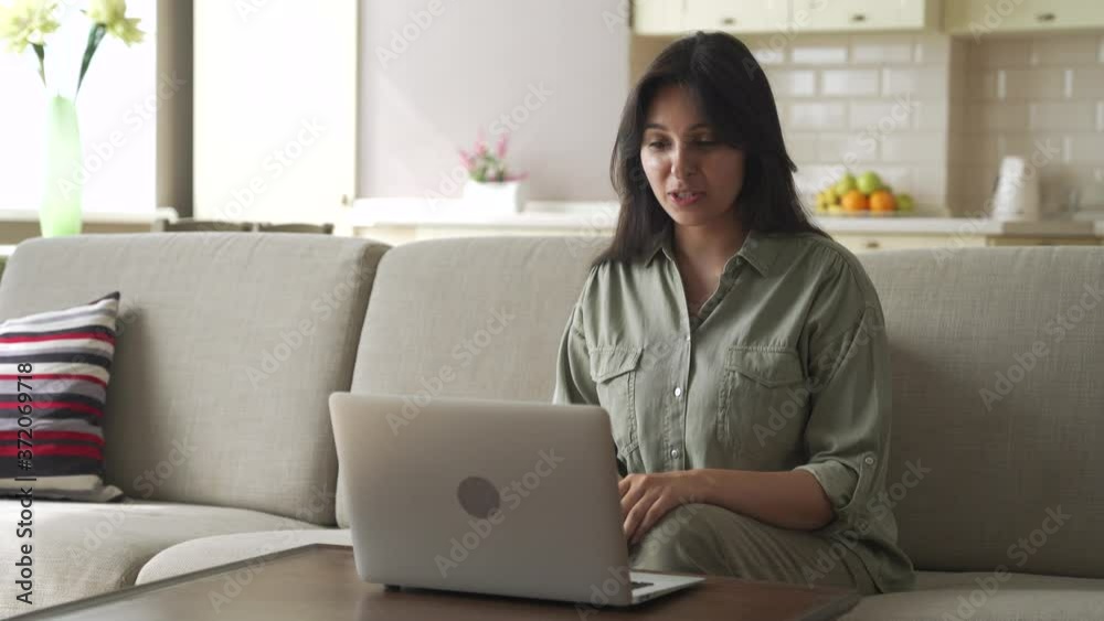 Smiling young indian woman video calling for remote job interview using laptop webcam conference work at home office. Happy lady talking by virtual chat meeting dating online using computer videocall. Smiling young indian woman video calling for remote job interview using laptop webcam conference work at home office. Happy lady talking by virtual chat meeting dating online using computer videocall.
