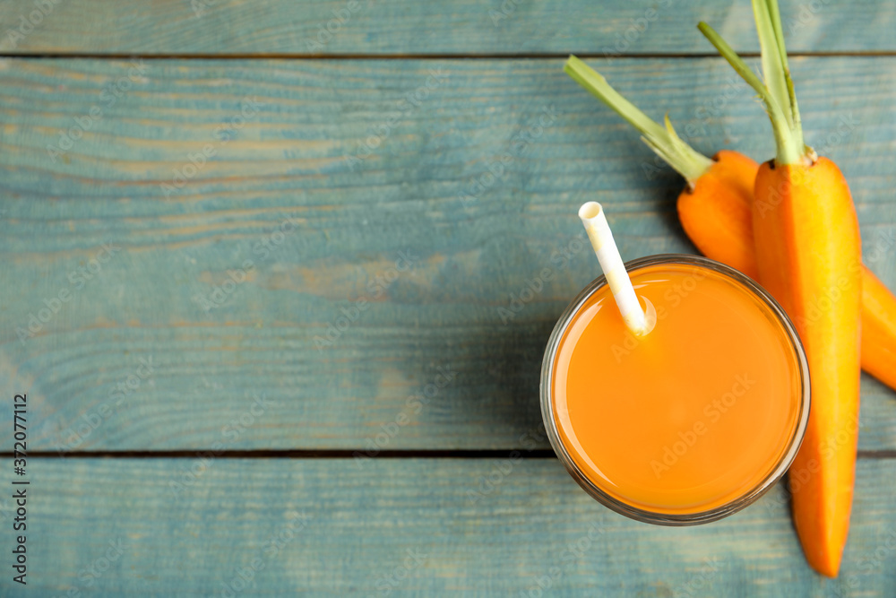 Freshly made carrot juice on wooden table, flat lay. Space for text Freshly made carrot juice on wooden table, flat lay. Space for text