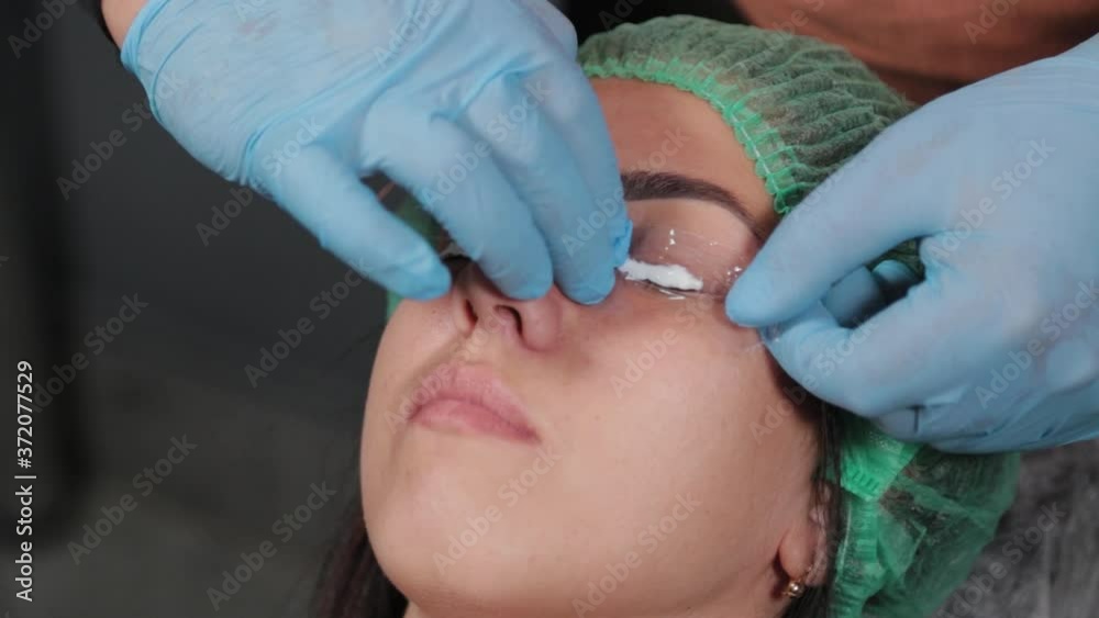 The permanent makeup artist applies an anesthetic to the lashes. The permanent makeup artist applies an anesthetic to the lashes.