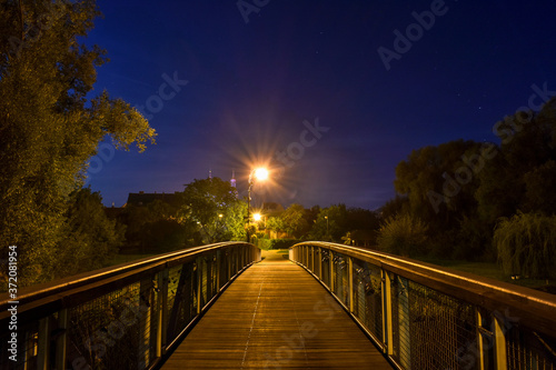 Wooden bridge with the night sky above © Tomasz