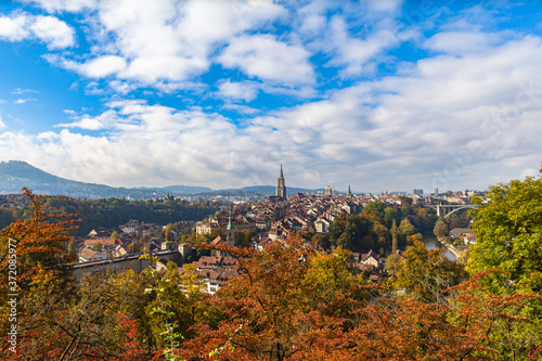Stunning aerial panorama view of Bern old town with Bern Minster  M  nster  cathedral and Aare river  from Rosengarten on sunny autumn day with blue sky and cloud  Switzerland