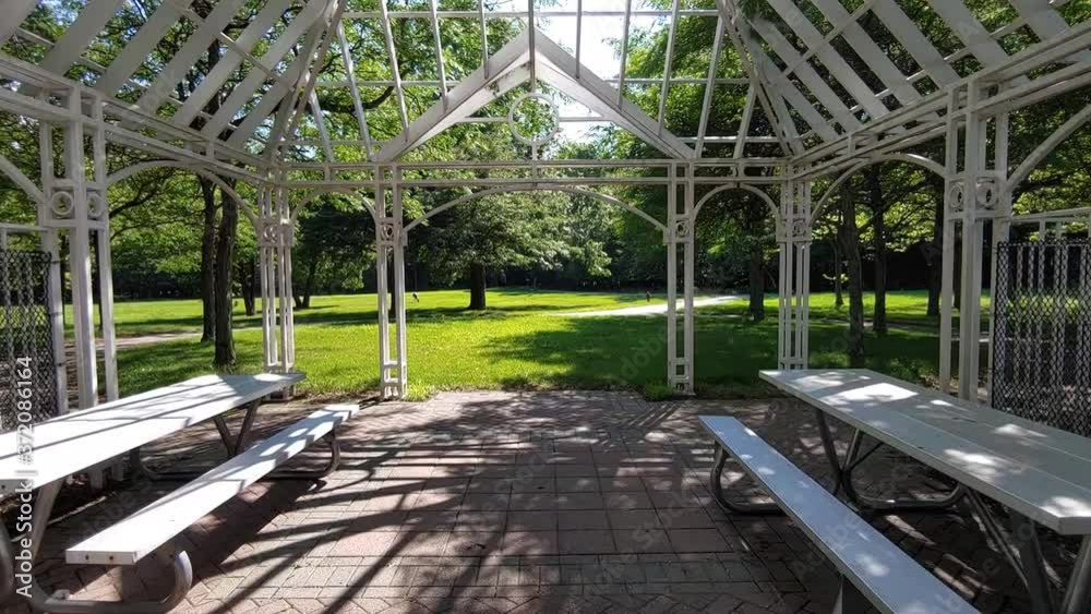 Entering a park through a white garden gazebo. Entering a park through a white garden gazebo.