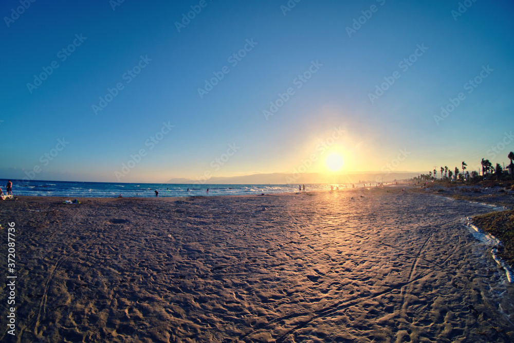 Sunset at sandy beach of Mediterranean sea