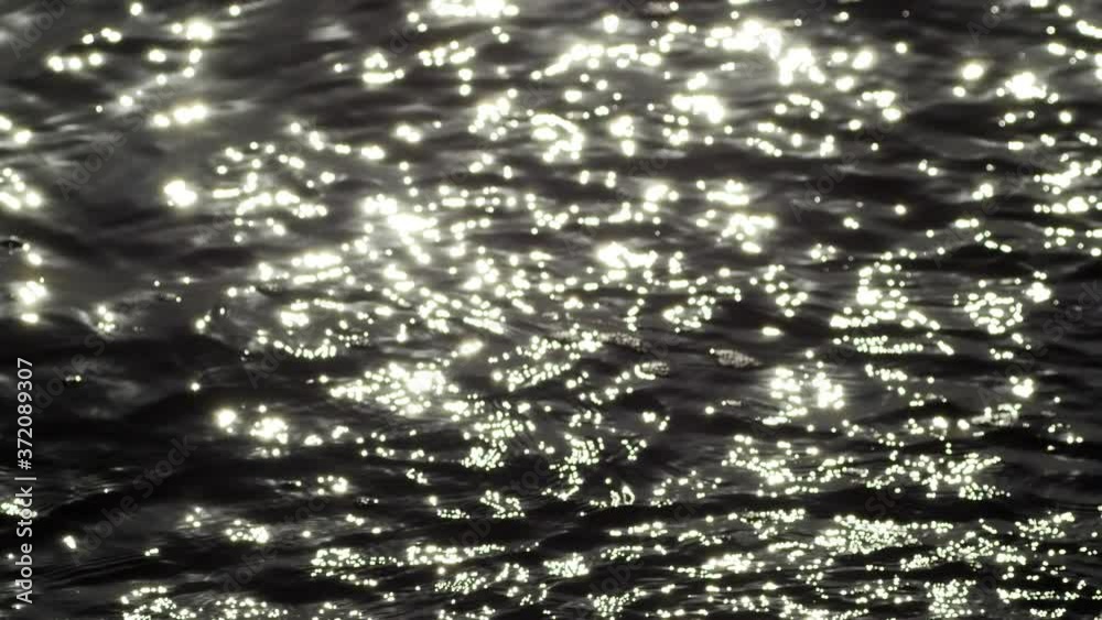 Looking over the calm water reflecting off the light. High Contrast B&W Close Up Liquid Texture Seamless Loopable Abstract Motion Background. Shimmering and trembling ocean surface at sunset. Reflecti Looking over the calm water reflecting off the light. High Contrast B&W Close Up Liquid Texture Seamless Loopable Abstract Motion Background. Shimmering and trembling ocean surface at sunset. Reflecti