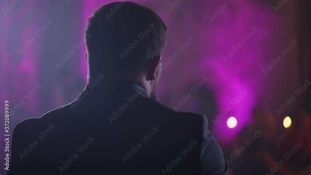 The soloist sings into the microphone, back view The soloist sings into the microphone, back view