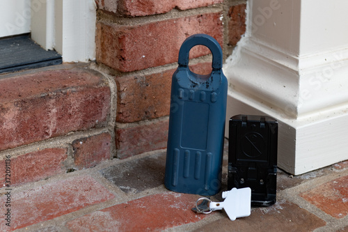 Real Estate electronic lockbox with key on a house entry porch photo