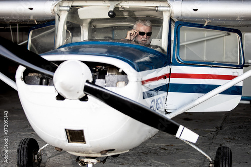Senior man pilot checking ultralight airplane before flight