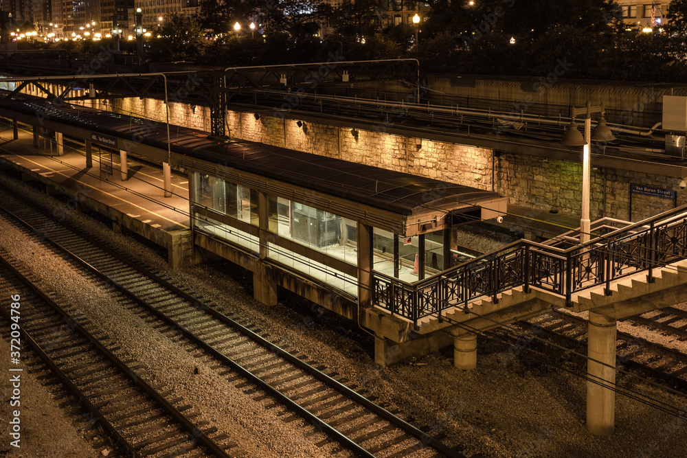 Empty shelter with lights on lonely train platform waiting for passengers