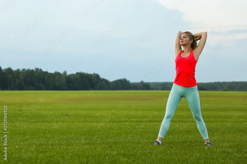 beautiful young woman doing sport exercises outdoor on sunset. 