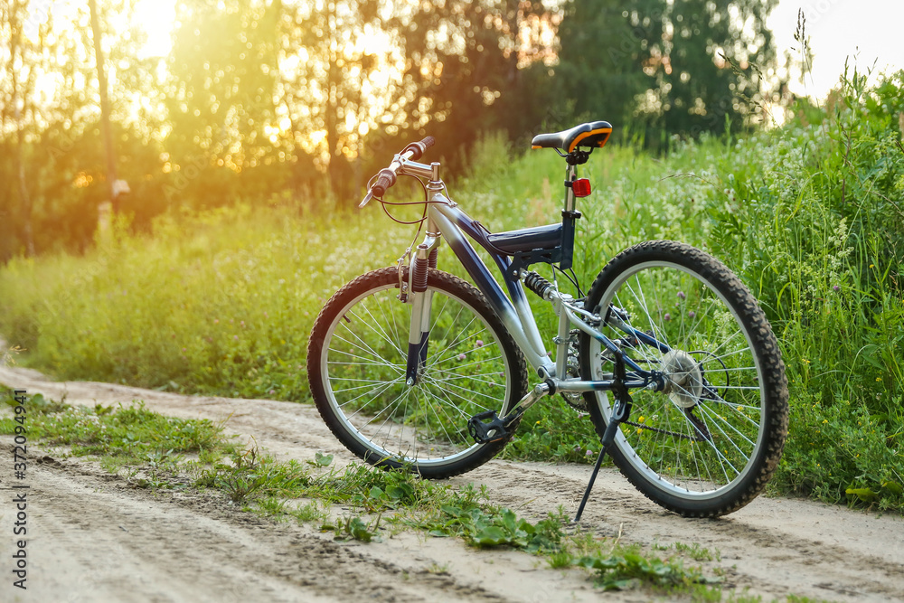 beautiful mountain bicycle on green nature background on sunset