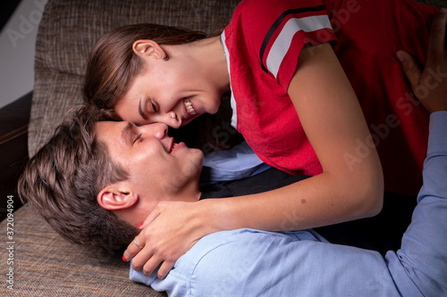 Close-up of a young romantic couple kissing and enjoying each other's company at home. The concept of romance and family