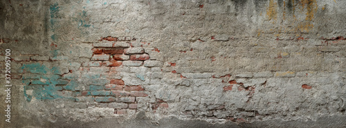 Old brick wall banner. Painted Distressed Wall Surface. Grungy texture. Grunge wall background. Building facade with damaged plaster.