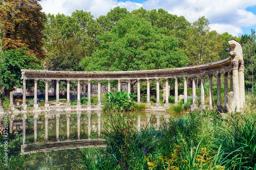 The famous classical roman colonnade in the Parc Monceau with relection in the pond - Paris, France. The garden designed by Carmontelle was finished in 1779.