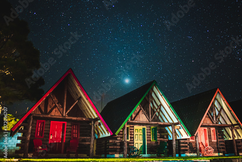 Beautiful wood cabins below a sky full of stars
