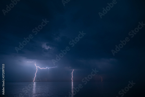 Lightning over water. Electric discharge. Nature background for design. Freshness concept.