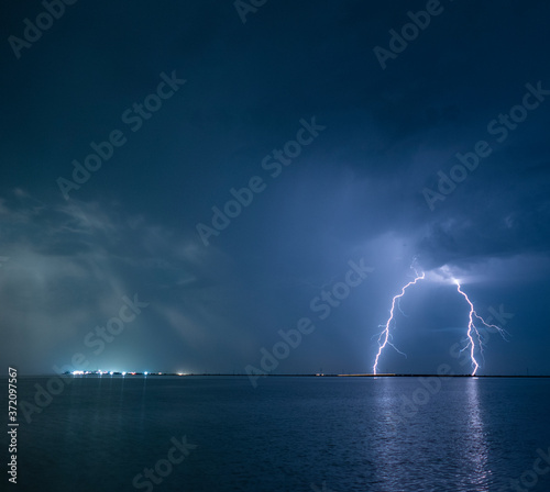 Lightning over water. Electric discharge. Nature background for design. Freshness concept.