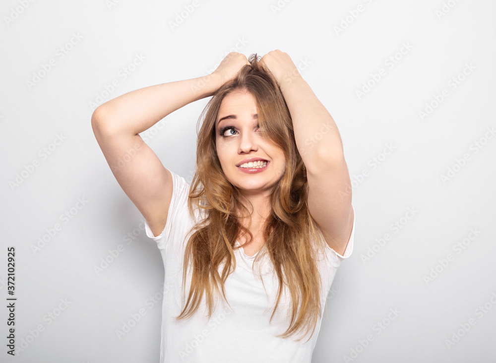 Thinking blond doubt grimacing woman looking up and thinking holding the head the hands on light blue background. Closeup portrait with empty copy space. Oops Thinking blond doubt grimacing woman looking up and thinking holding the head the hands on light blue background. Closeup portrait with empty copy space. Oops