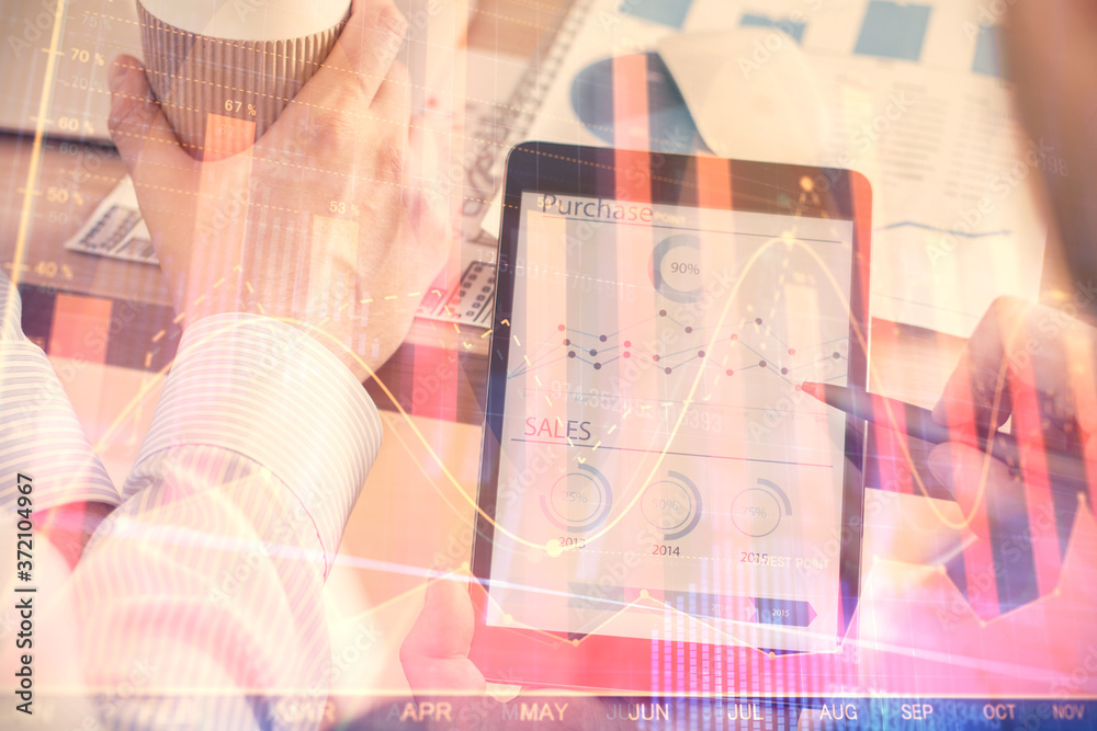Double exposure of man's hands holding and using a phone and financial chart drawing. Market analysis concept.