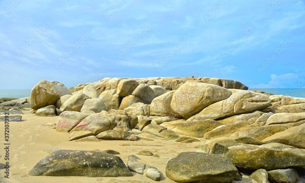 On the seashore there are many large rocks piled together. On the seashore there are many large rocks piled together.