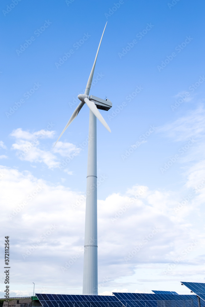 Alternative Energy Concepts. Windmill Outdoors Against Blue Sky. Vertical image