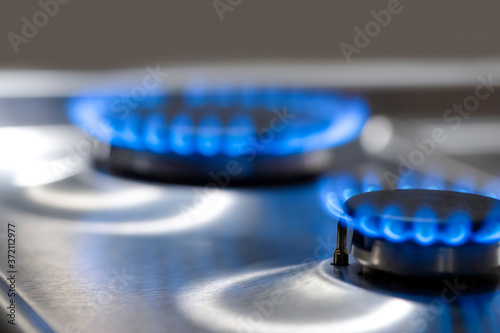 Gas Oven Concepts. Macro Shoot of Two Gas Burners on Stove Surface with Flames.