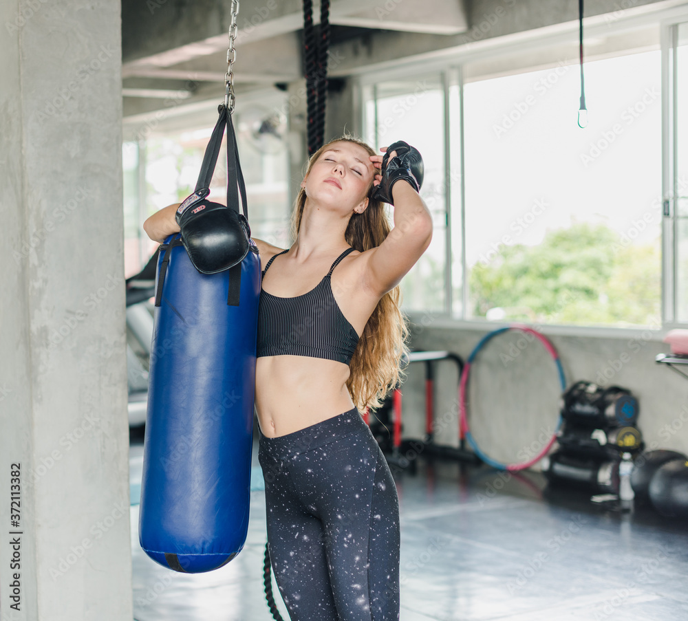 Female athletes punching sandbags to exercise in the gym.