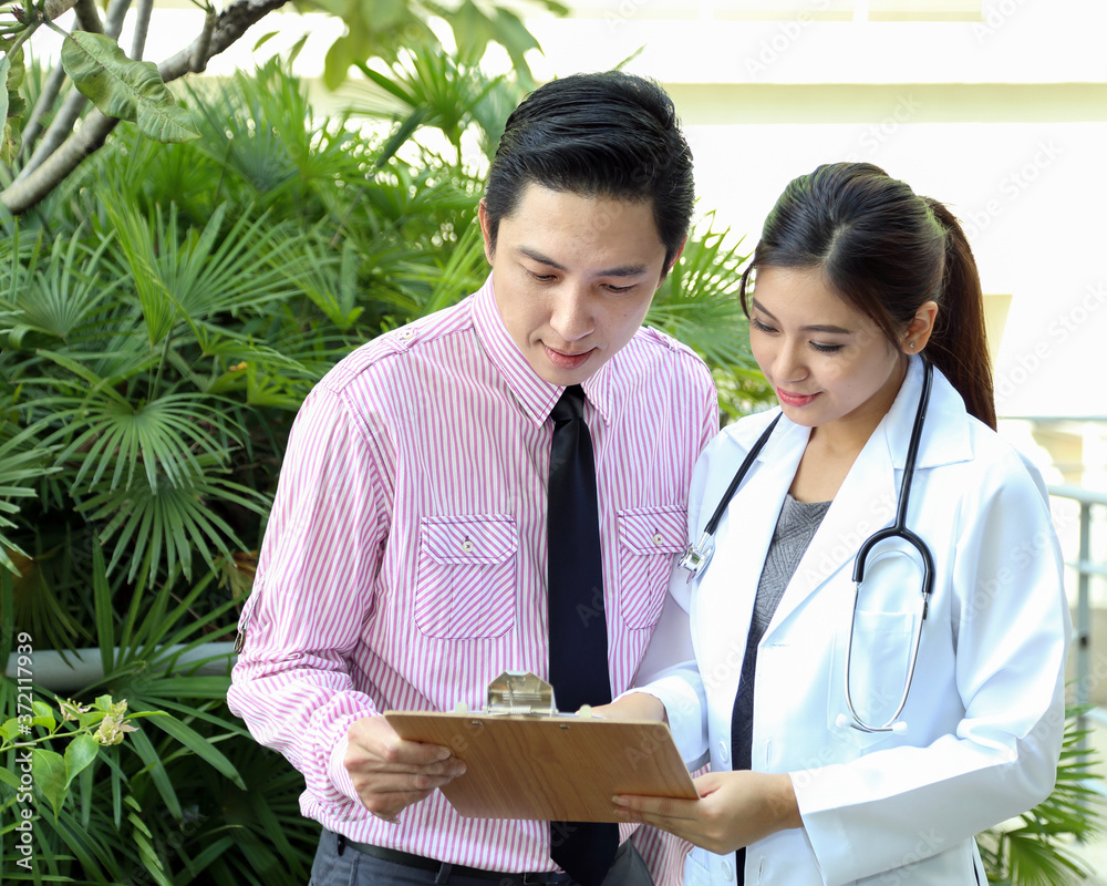 South East Asian young Malay Chinese man woman medical doctor talking discussing outdoor South East Asian young Malay Chinese man woman medical doctor talking discussing outdoor